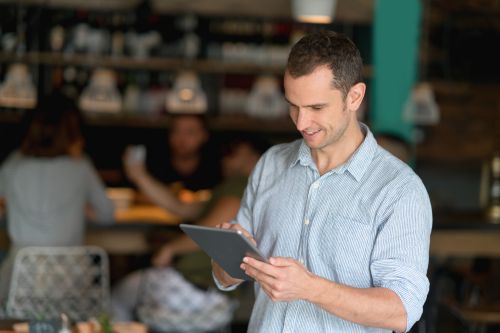 A restaurant manager working on tablet